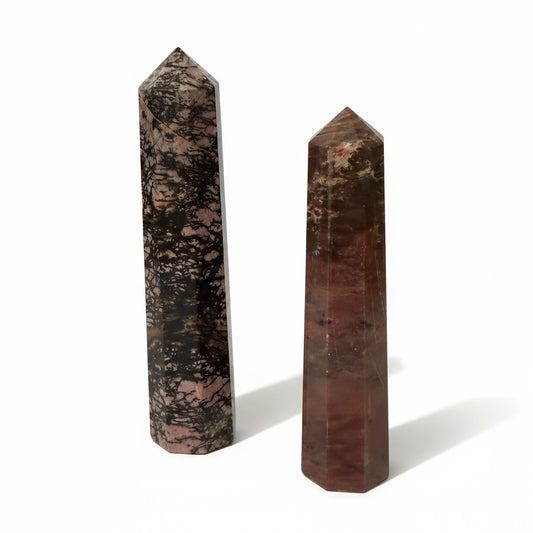 Two polished stone obelisks on a white background