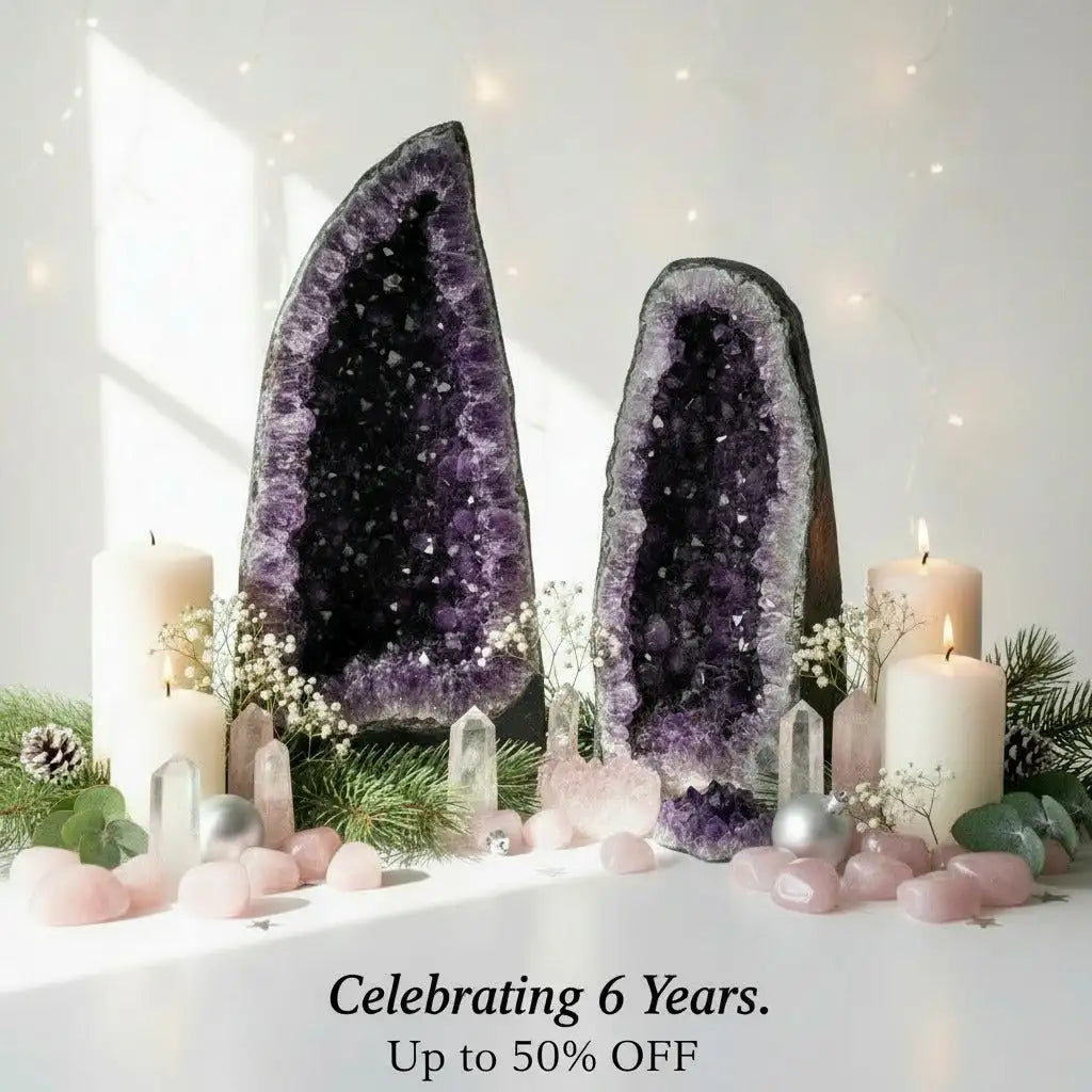 Two tall, vertically oriented amethyst geodes with deep purple crystalline interiors and dark outer shells.